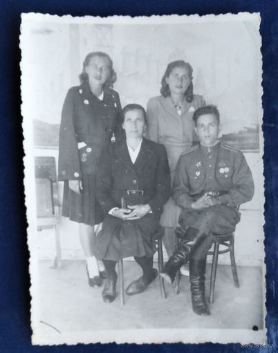 Фото военного с наградами и трех женщин.